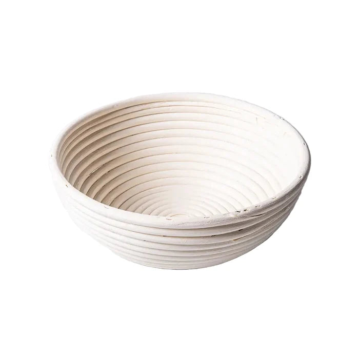 Round 10-inch Port Style Banneton basket for bread proofing, made of natural rattan with a coiled pattern.