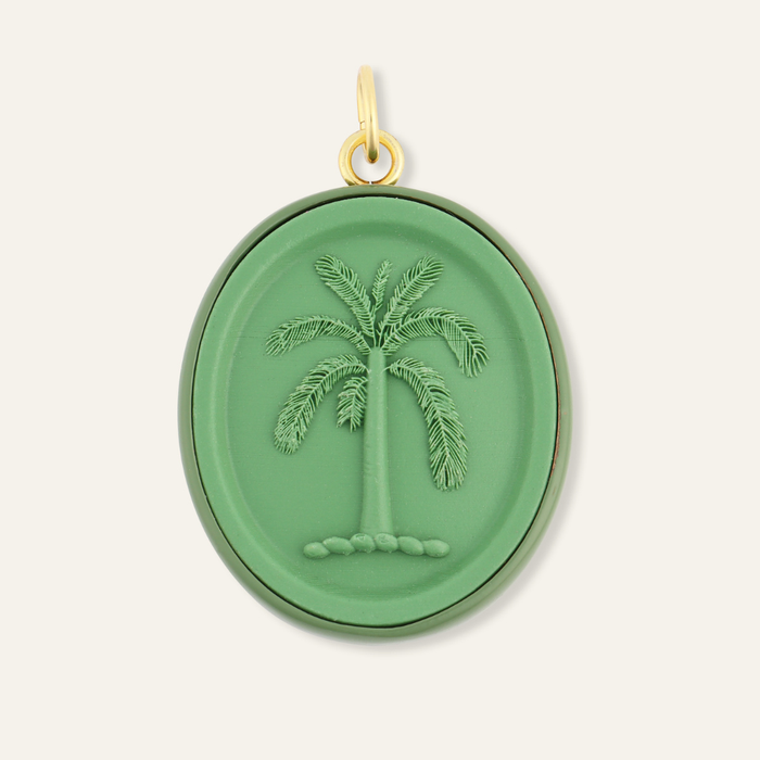 Green pendant with palm tree design on a white background. Palm cameo charm