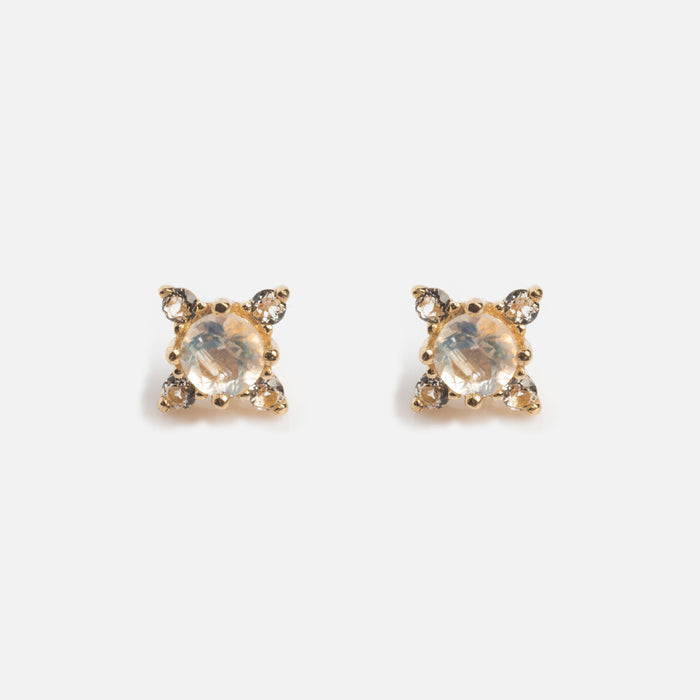 A pair of Solid Gold Moonstone Flat Back Studs featuring a central round moonstone, each accented by four smaller clear stones in a square pattern, displayed on a white background.