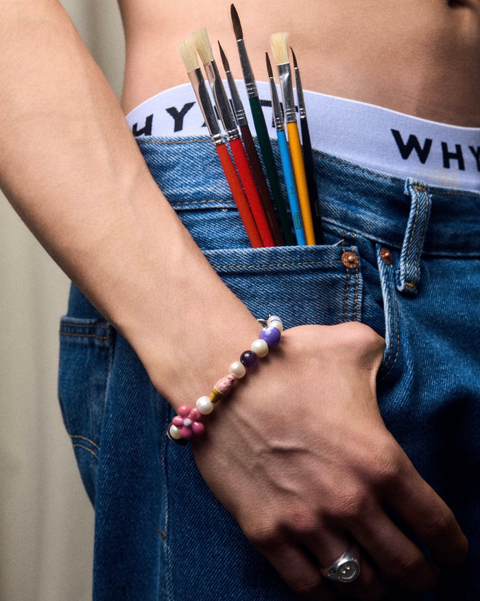 Lilanes Armband mit bunten Charms-Perlen, filigranes Band mit violetten Perlen und farbigen Akzenten für ein verspieltes, stilvolles Design.