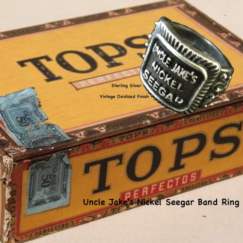 Even if you are not a cigar aficionado, this vintage cigar band ring is "smoking". The first in what will be an expansive and whimsical collection,  this 3D version of an actual antique "Seegar" band--the first of its kind. Sterling Silver in my antique satin oxidized finish to bring the old cigar band to life once again!  Top 1/2" wide approximately.  Made in the USA by hand. Hand signed.  Sterling Silver Uncle Jake's Nickel Seegar Cigar Band Ring.  Be sure to check out my other two cigar band rings--Mild