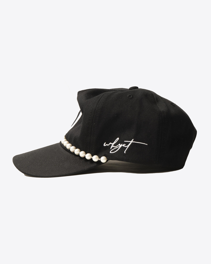 Black W cap with white embroidered ‘W’ logo and pearl necklace