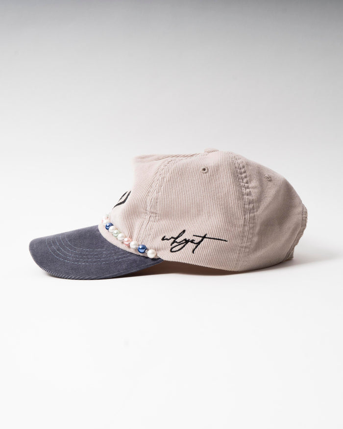 W Cap- Stylish cord cap featuring a black W logo and elegant pearl chain.